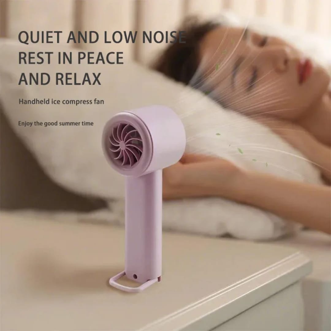 A white or pink handheld mini portable rechargeable fan with a built-in stand, blowing a cool breeze. The fan is lightweight and has a modern, minimalist design.